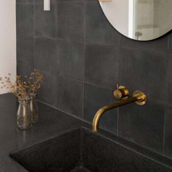 Huguet - Customized cement washbasin and black tiles.